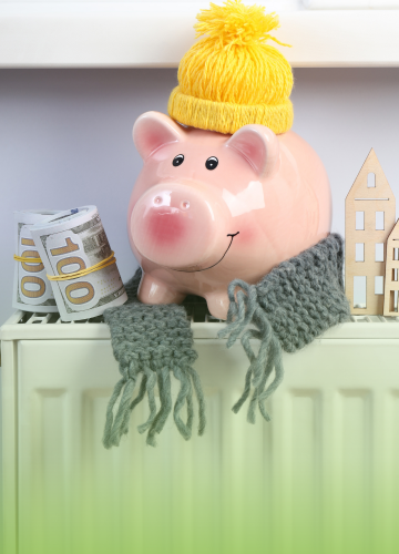 a piggy bank wearing a scarf and sitting on the radiator