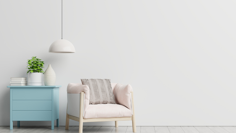A white room with a hanging light over a blue end table and chair