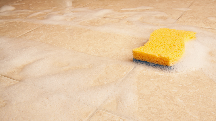 a yellow sponge wiping and cleaning on a wooden floor